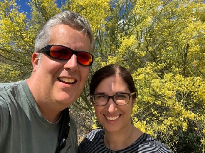 A couple posing with love on a summer afternoon with green tree
