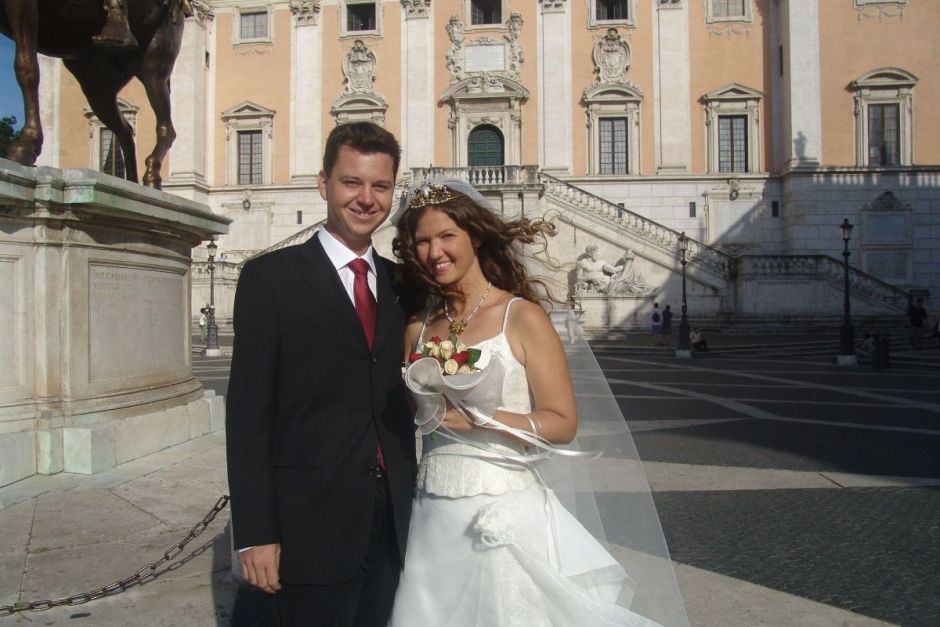 A couple pose in front of a grand building on their wedding day as they start the journey of their love