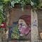 A woman painted on the wall in Istanbul with green plants covering the area