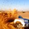 A car bashing through sand dunes