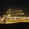 A zigzag road going down the mountain and many lights on it